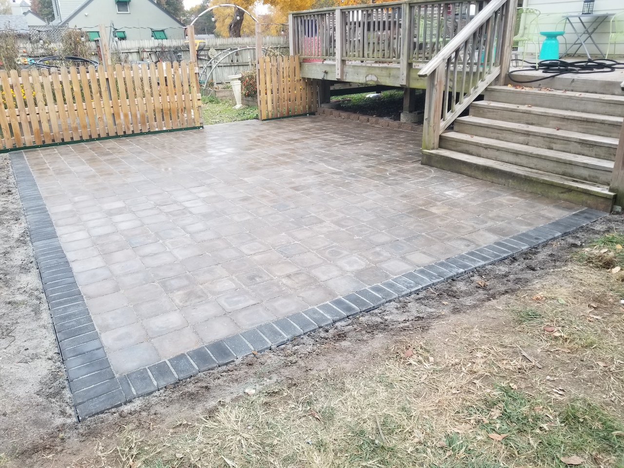 Back concrete patio landscape design off deck by Evolving Landscapes in Lee's Summit, MO