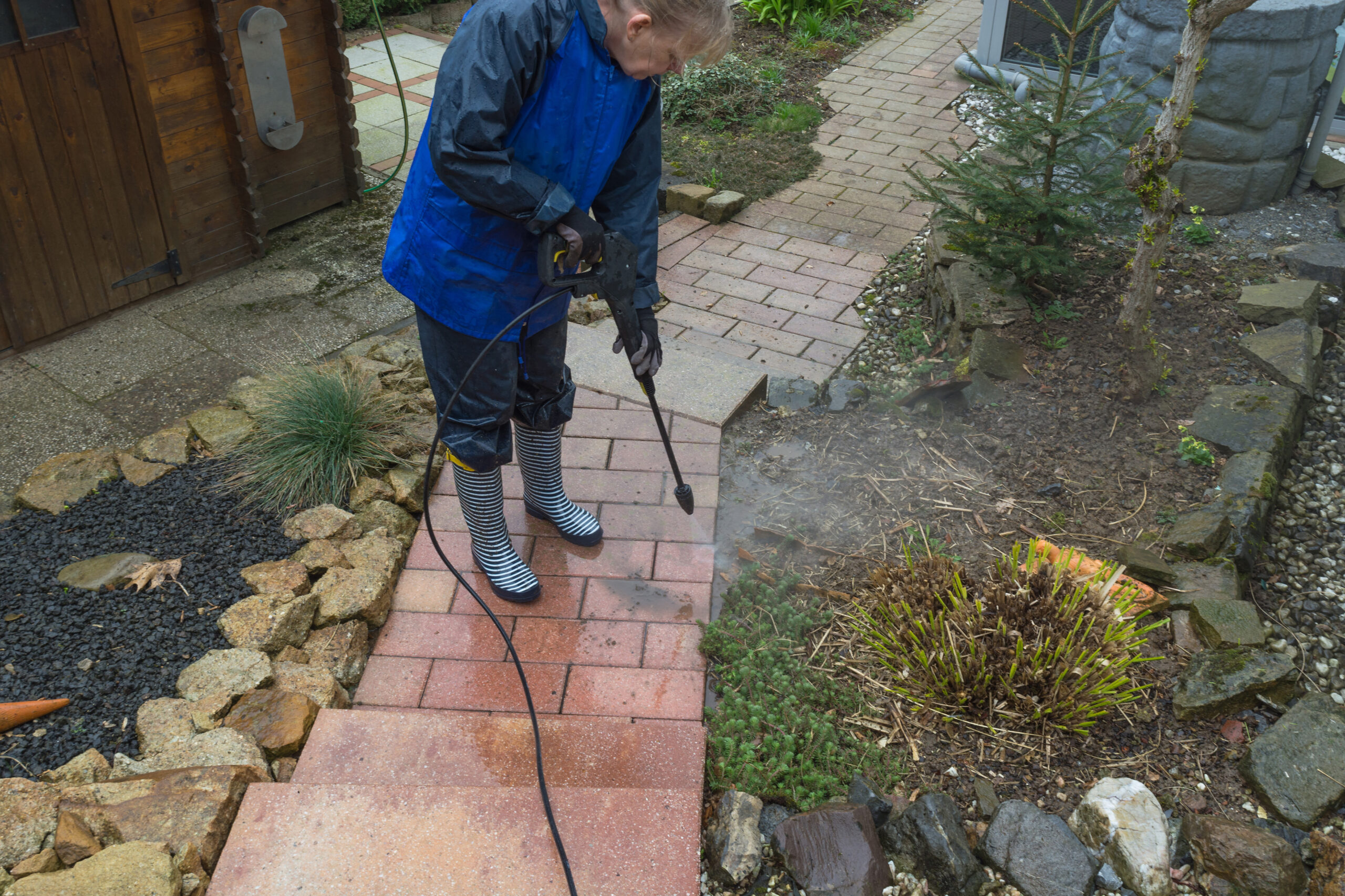 Using a pressure washer to clean a concrete patio